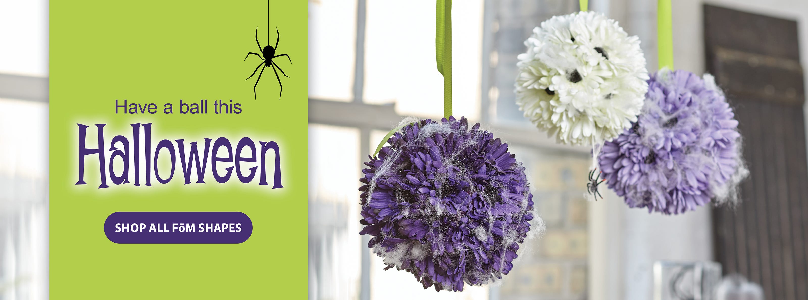 Floral pomander balls made with craft foam, flowers, and ribbon hang from the ceiling as elegant Halloween decor
