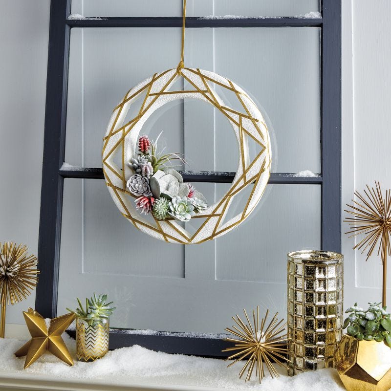 Modern succulents displayed in a white and gold shaped ornament wreath