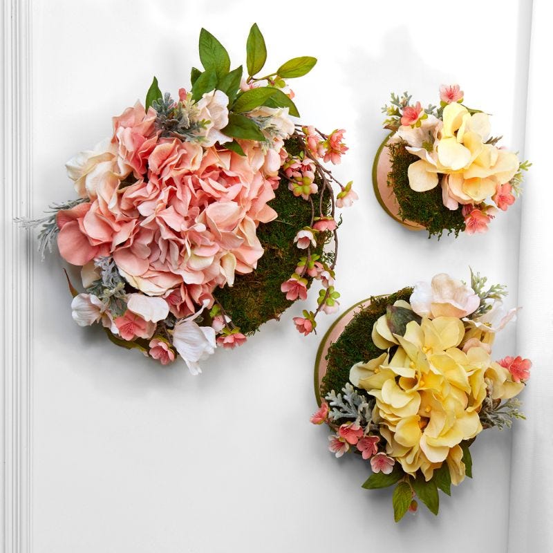 Multiple types of ribbons decorating a heart shaped foam wreath that is hung on a white door