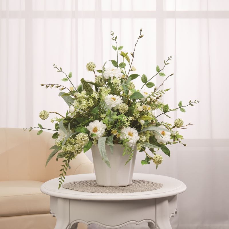 Greenery and wildflowers arranged in a white EasyAnchor floral container and displayed on a table